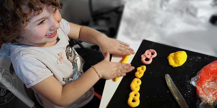 Mädchen bastelt mit ungifter essbarer und selbstgemachter Knete