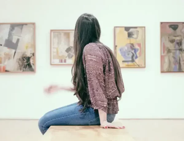 18-Jährige sitzt vor Gemälden, den Eintritt hat sie mit dem Kulturbonus bezahlt